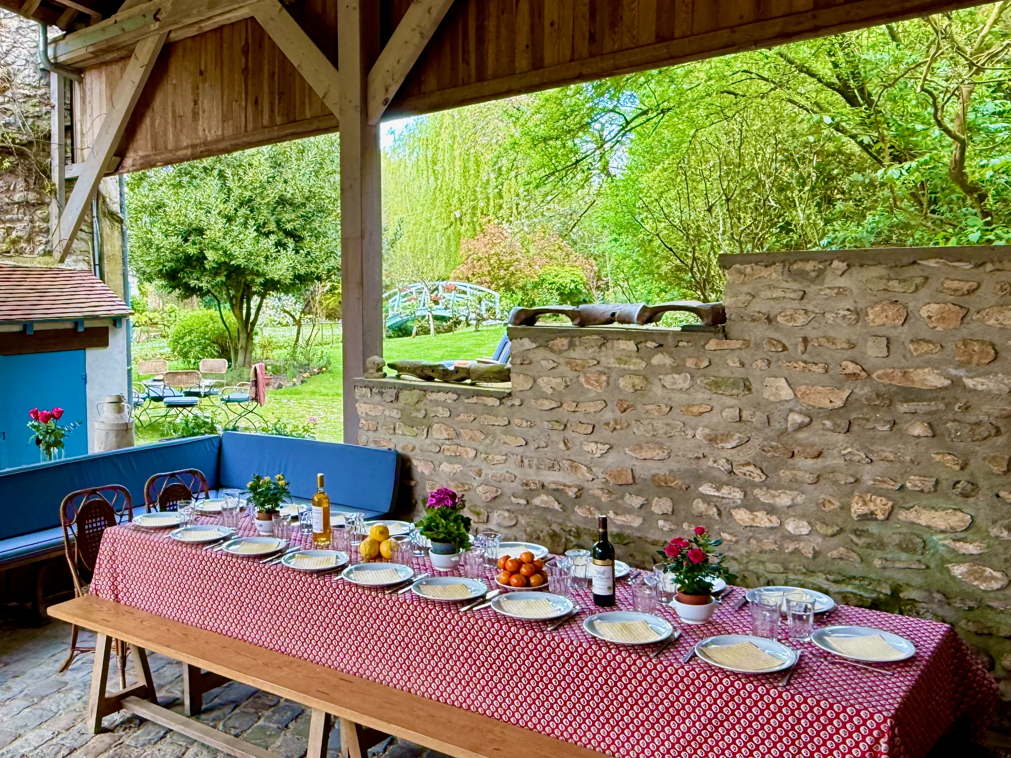 The long table set under La Grange's pavilion with the garden and painted bridge beyond