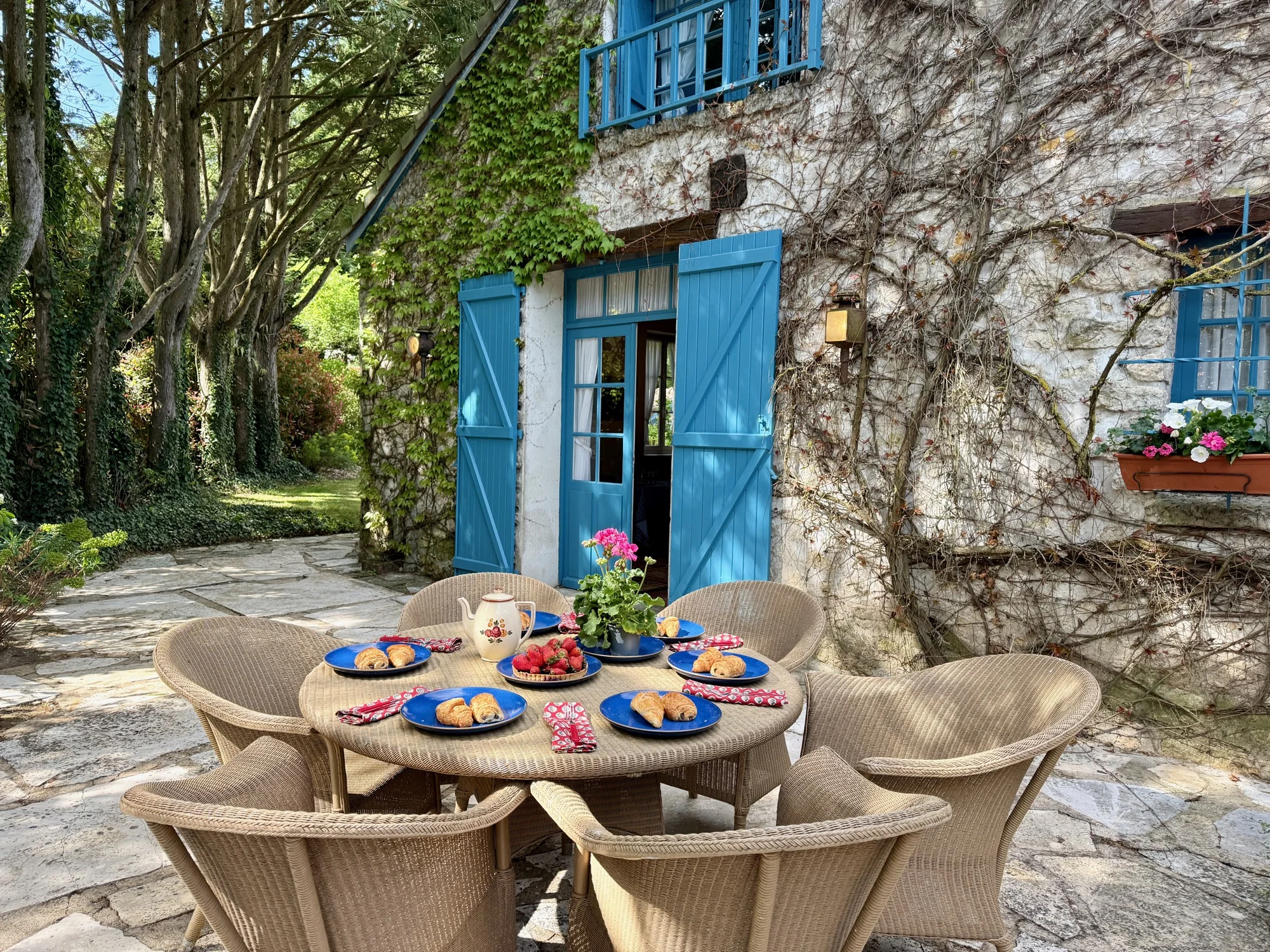The Hollywood Hideaway — breakfast table on the patio facing the blue-shuttered facade