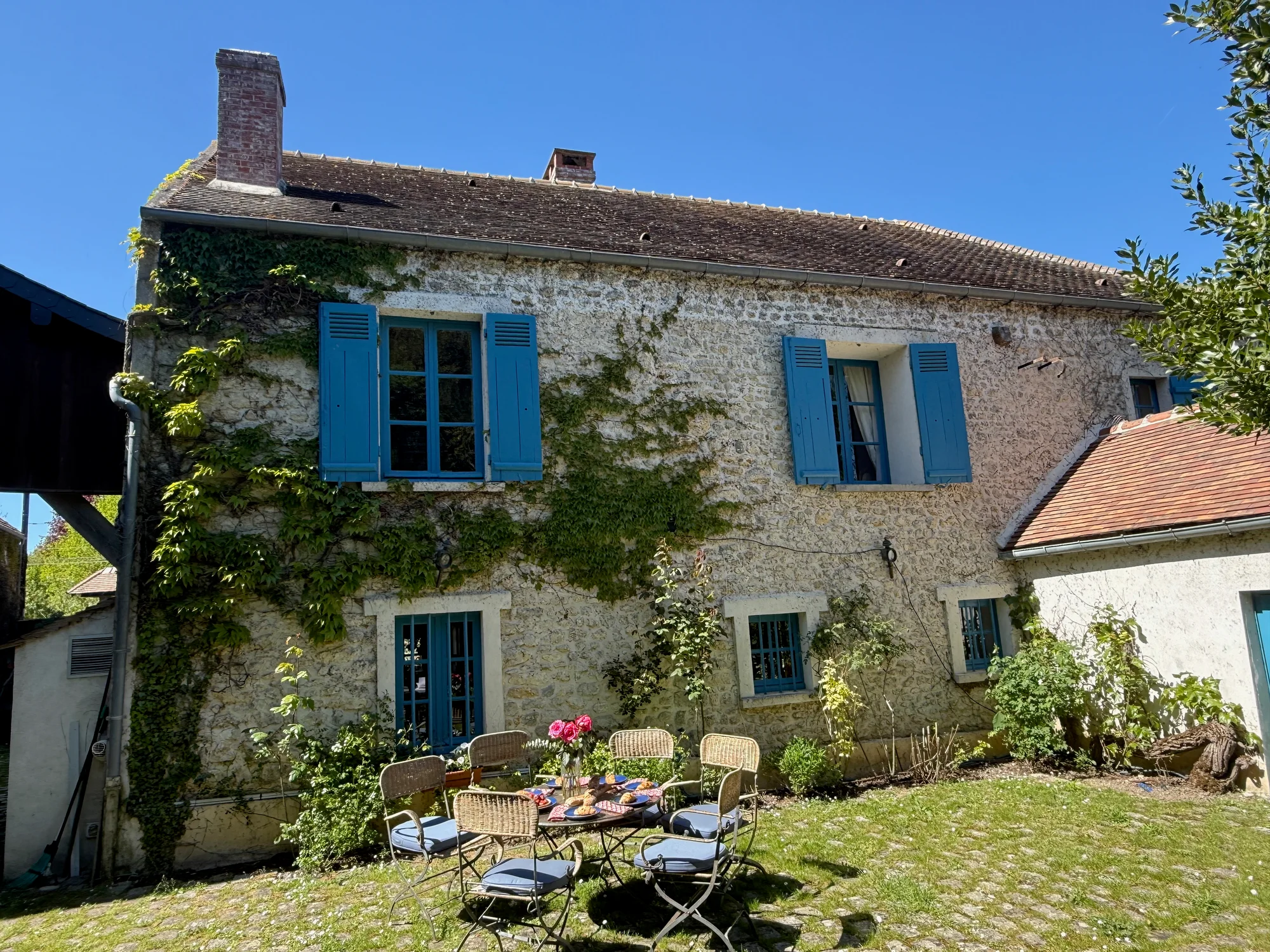 Back patio with cafe seating outside the stone facade