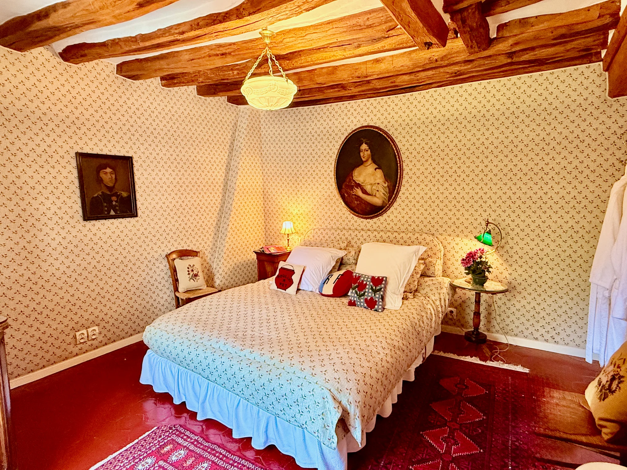 Les Cerises — the Cherry Room with portraits and patterned bedspread