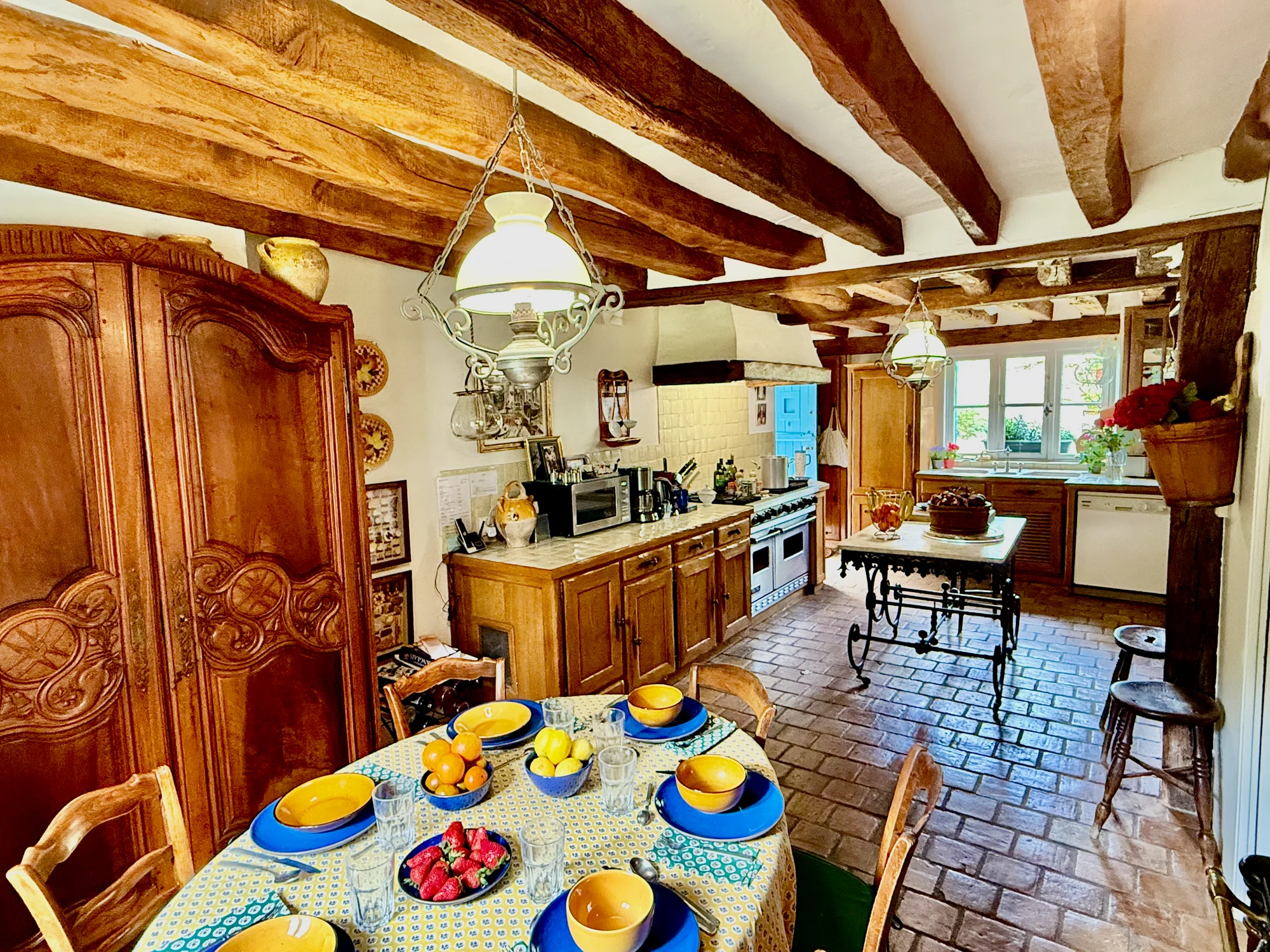 Eat-in kitchen with French armoire and Viking-style ovens at Le Moulin