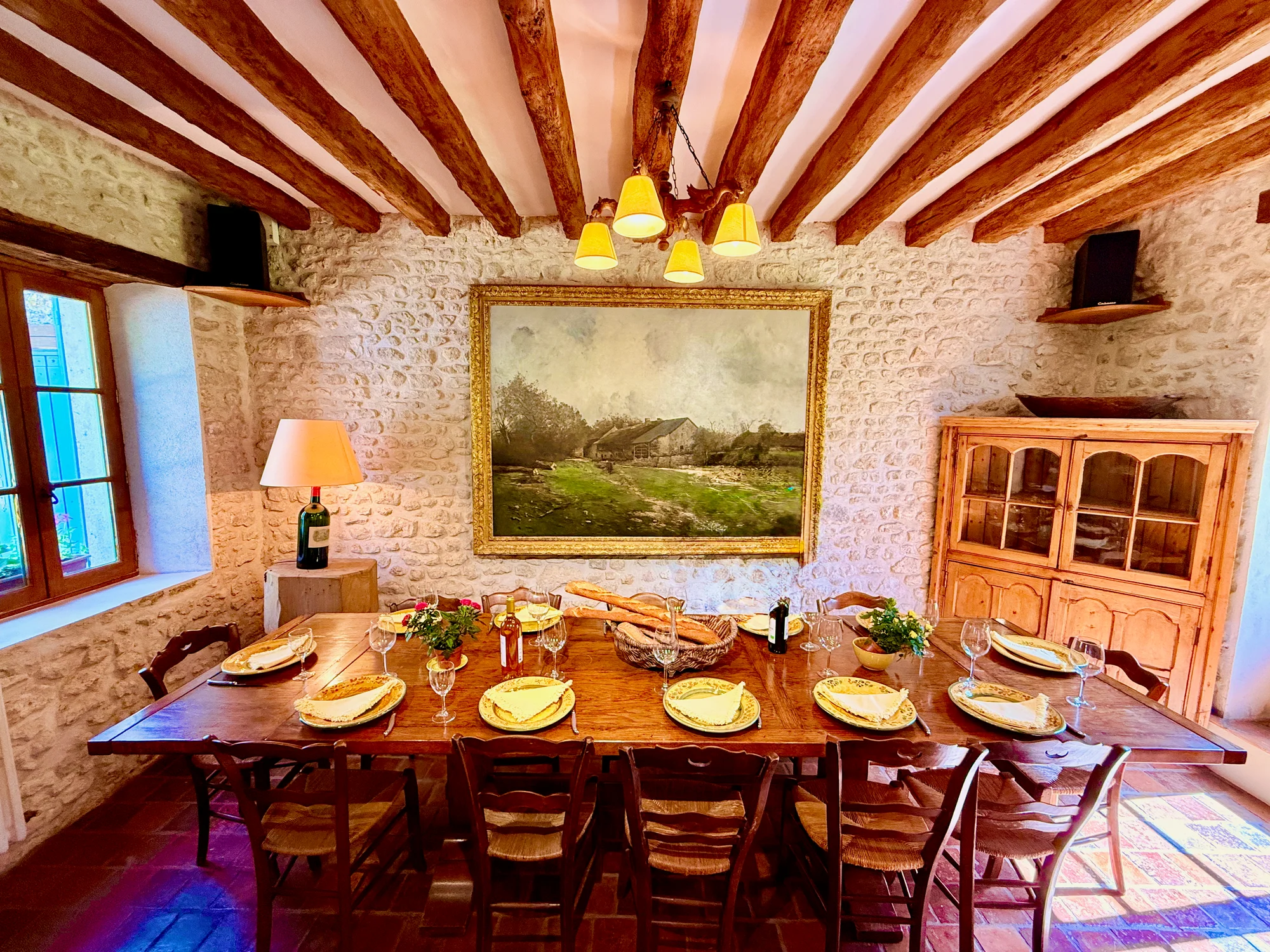 Dinner laid on the long dining table, lit by warm chandelier light