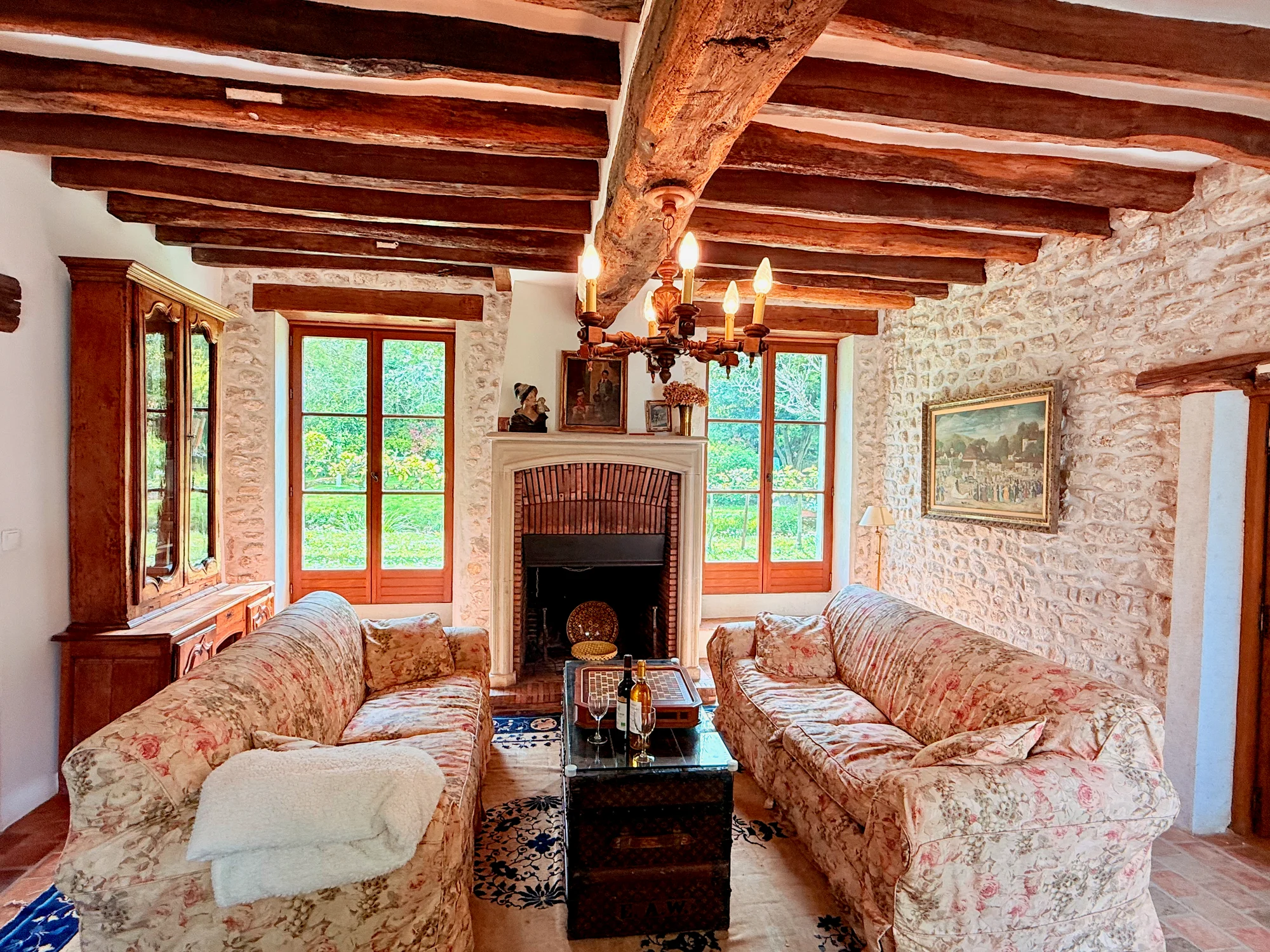 Living room facing the stone fireplace with floral couches